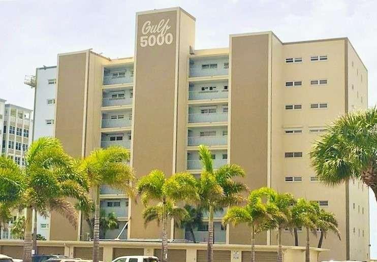 A multi-story tan apartment building features a central tower labeled Gulf 5000 and palm trees — 5000 GULF BOULEVARD UNIT 303, ST PETERSBURG, FL