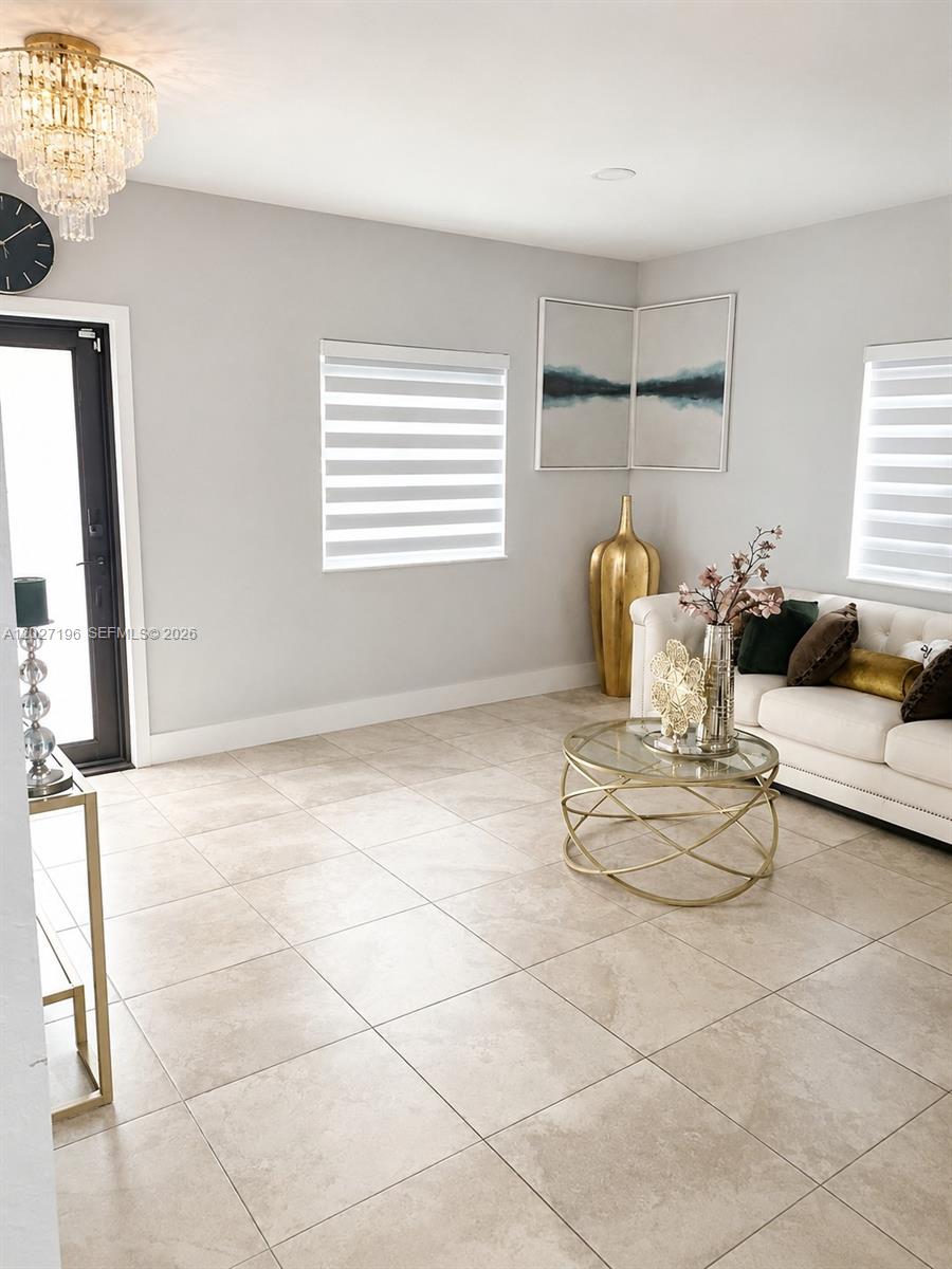 A living room features a white sofa, two green velvet chairs, and gold-toned accents — 2221 NW 57th St, Miami FL 33142, MIAMI, FL