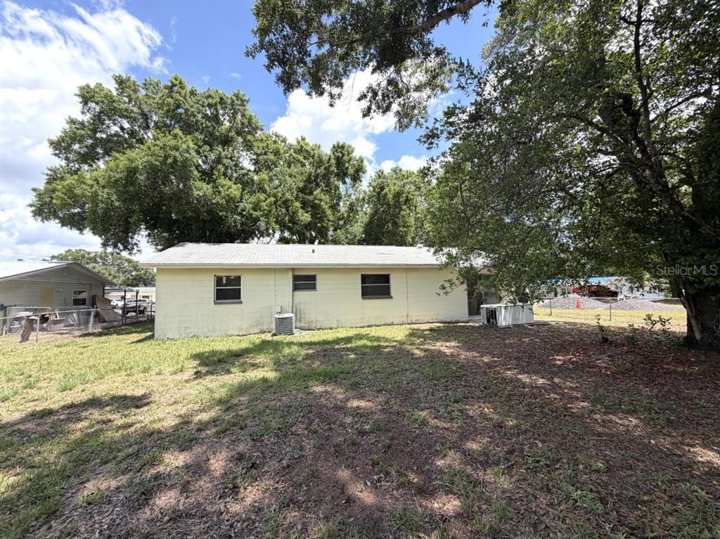 The exterior of a light-colored, single-story concrete block house with a shingled roof — 3145 FLETCHER AVENUE, LAKELAND, FL
