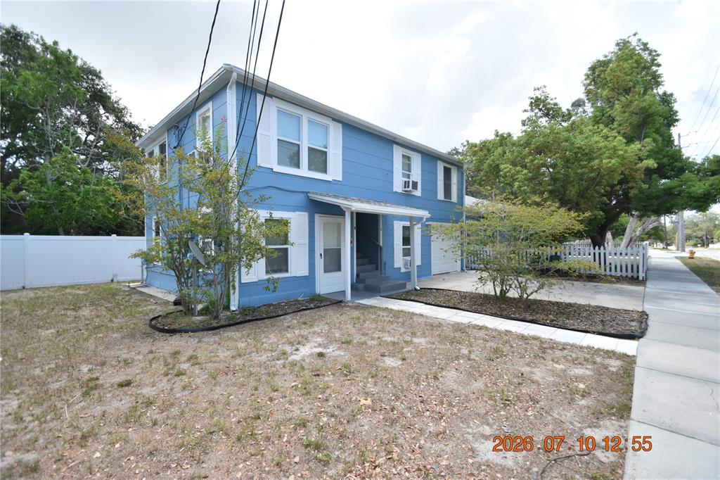 A two-story blue house with a white fence and a concrete driveway — 1156 SUNSET POINT ROAD UNIT A, CLEARWATER, FL