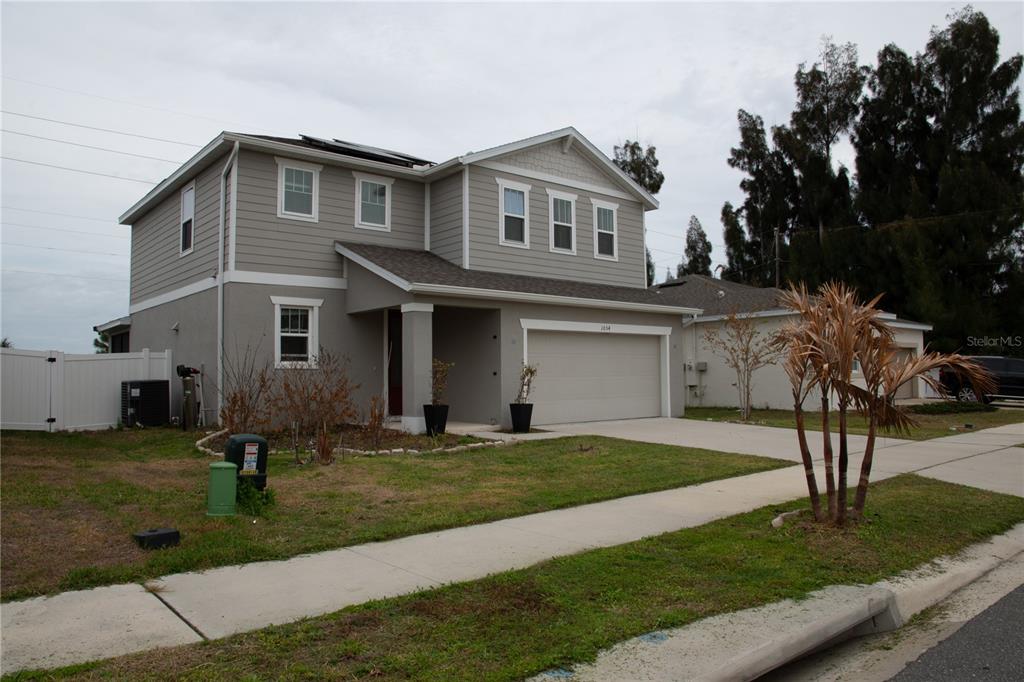 A two-story suburban house with gray siding, a two-car garage, and a front lawn — 1054 HEIRLOOM DRIVE, HAINES CITY, FL