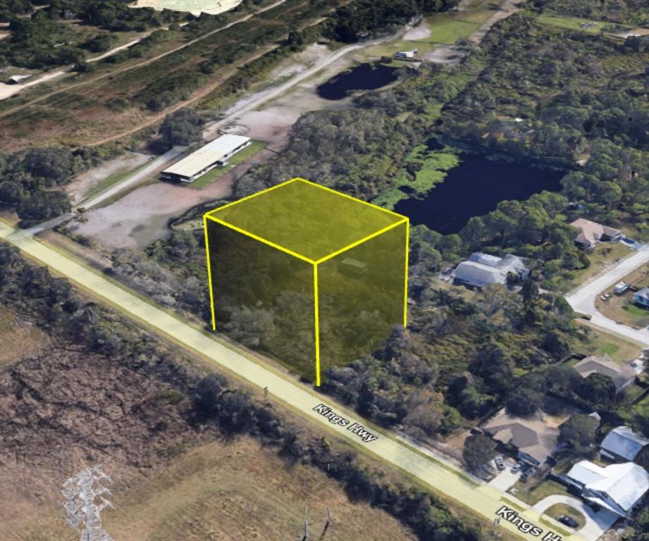 An aerial view shows a vacant, wooded lot highlighted by a yellow box near a road — 4265 KINGS HWY, COCOA, FL