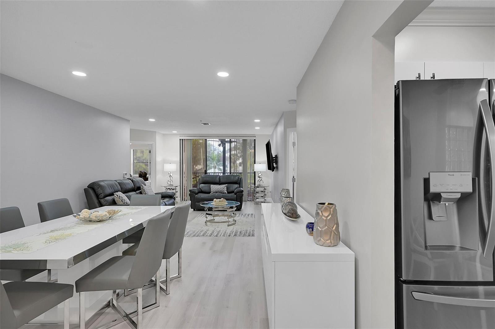 A dining area and living room with white furniture, gray chairs, and light wood flooring — 5133 Brisata Circle # P, Boynton Beach FL 33437, BOYNTON BEACH, FL