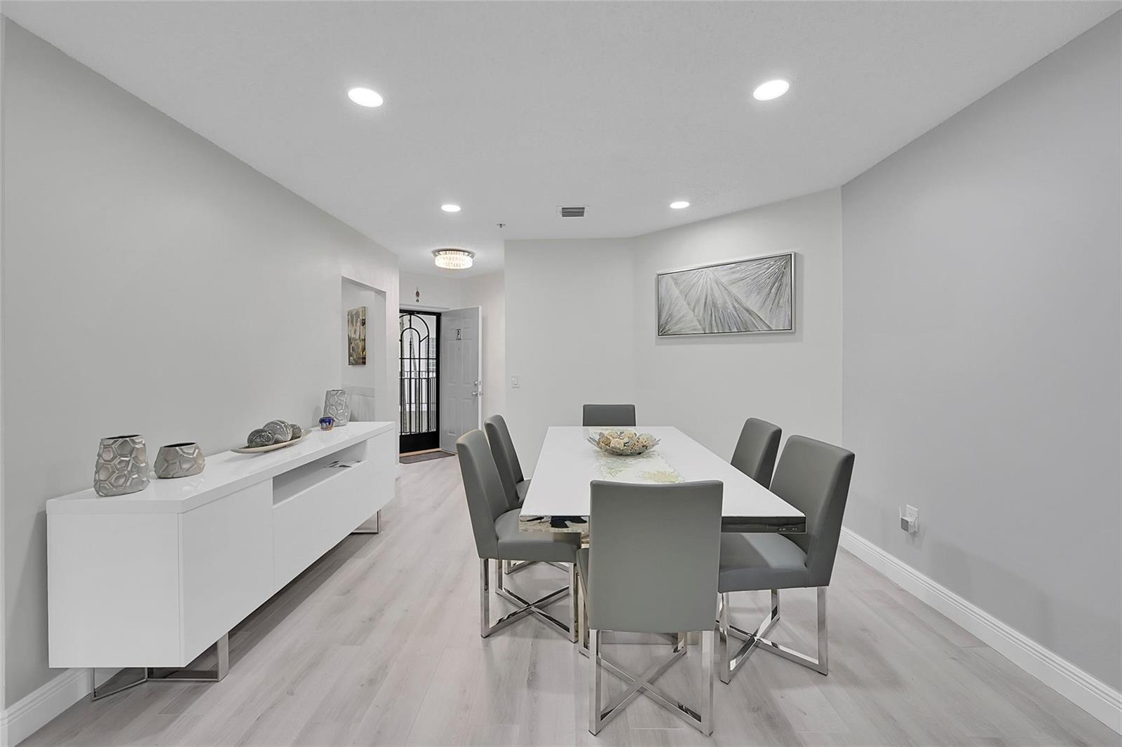 A dining room features a white table, six grey chairs, and a white sideboard — 5133 Brisata Circle # P, Boynton Beach FL 33437, BOYNTON BEACH, FL