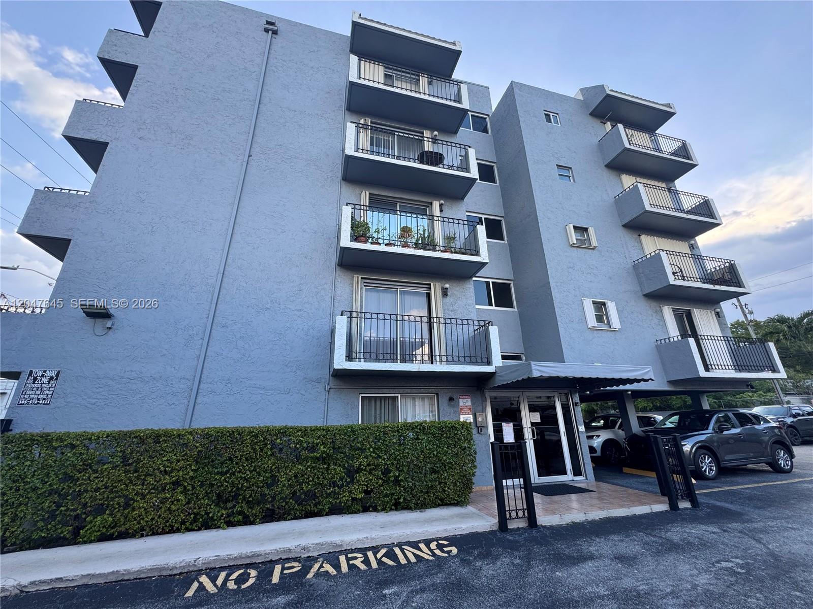 A multi-story blue apartment building features balconies and a ground-level entrance with covered parking — 1933 SW 7th St # 504, Miami FL 33135, MIAMI, FL