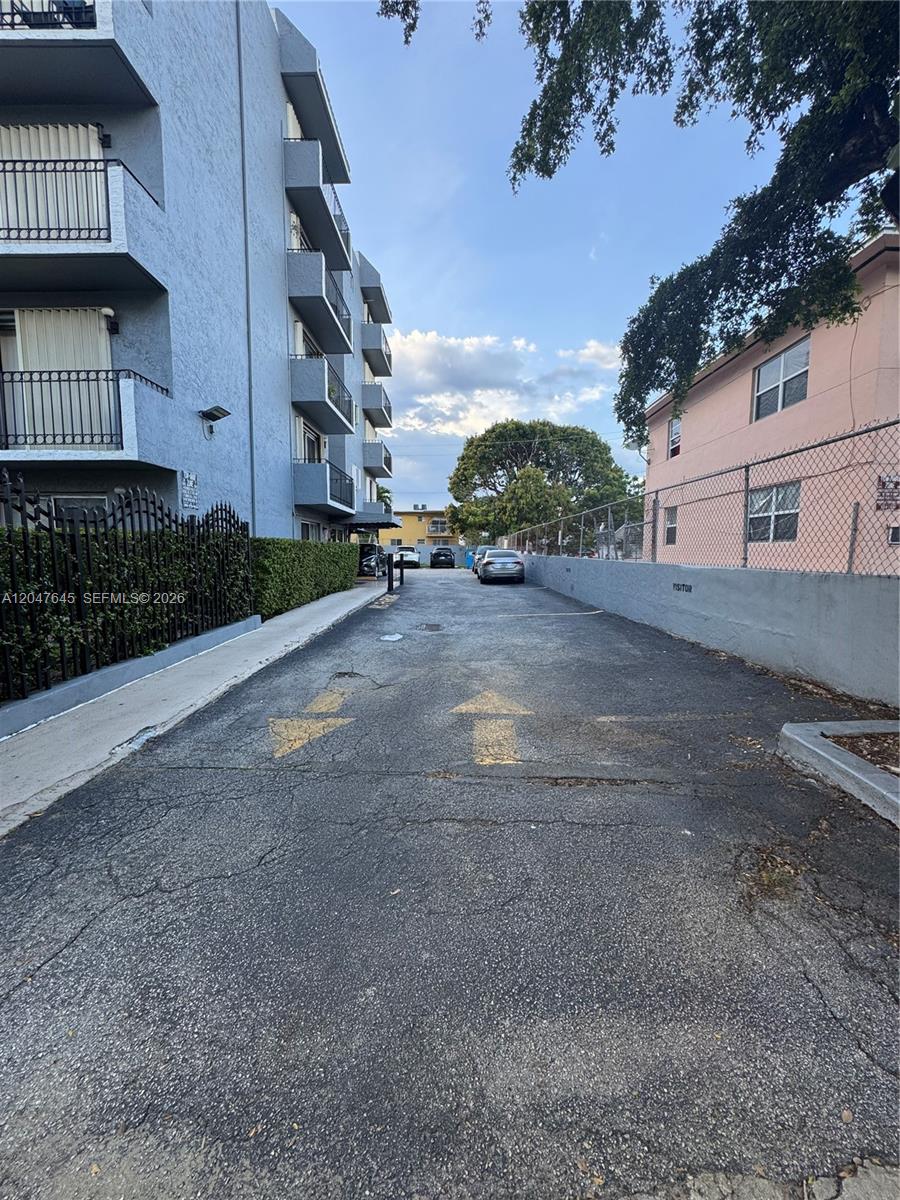 An outdoor parking area sits between a blue apartment building and a pink building — 1933 SW 7th St # 504, Miami FL 33135, MIAMI, FL