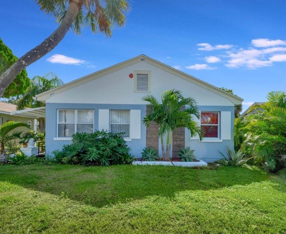 A single-story house with blue and white exterior walls, a palm tree, and a lawn — 340 78TH AVENUE, ST PETE BEACH, FL