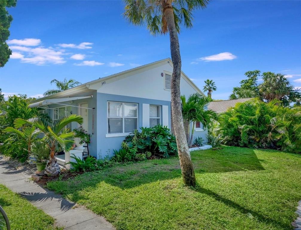 A light blue single-story house with a palm tree in the front yard — 340 78TH AVENUE, ST PETE BEACH, FL