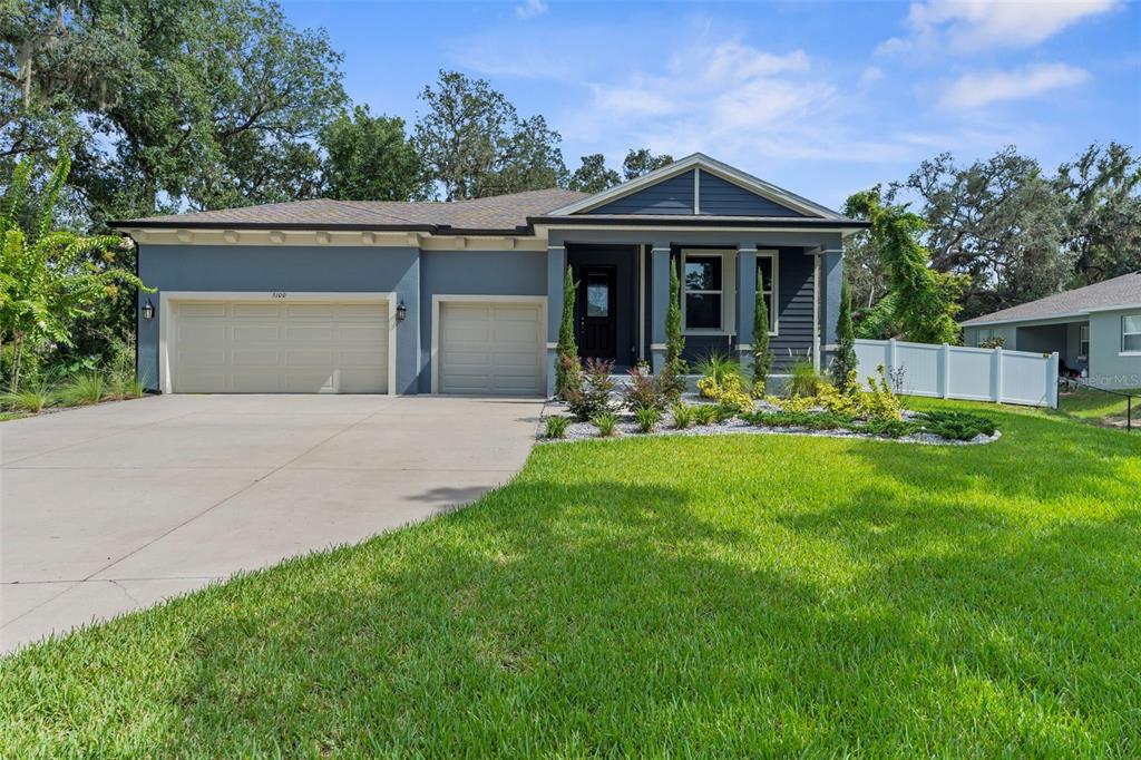 A blue single-story house with a two-car garage and a front porch — 5100 WESTLAKE BOULEVARD, DADE CITY, FL