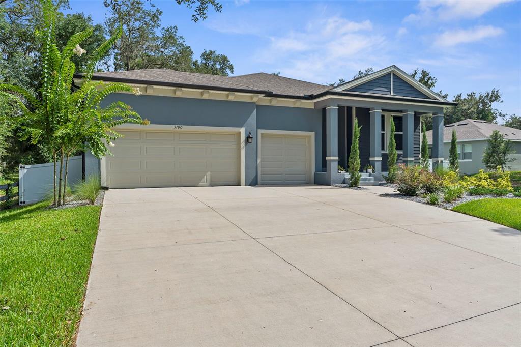 A blue single-story house with a three-car garage and a covered front porch — 5100 WESTLAKE BOULEVARD, DADE CITY, FL