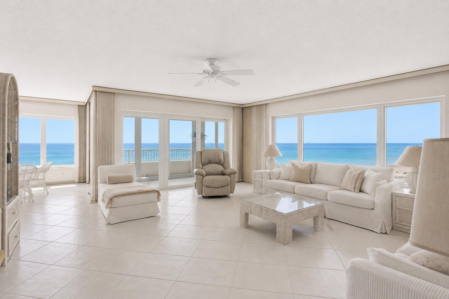 A bright living room with white tile floors, neutral furniture, and expansive ocean views — 600 S Ocean Boulevard # 6010, Boca Raton FL 33432, BOCA RATON, FL