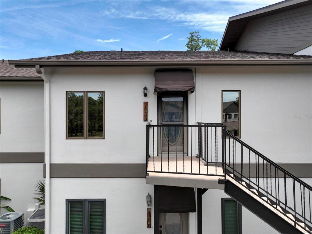 An exterior view of a two-story building with a balcony and metal staircase — 7032 RIVER RUN BOULEVARD, WEEKI WACHEE, FL