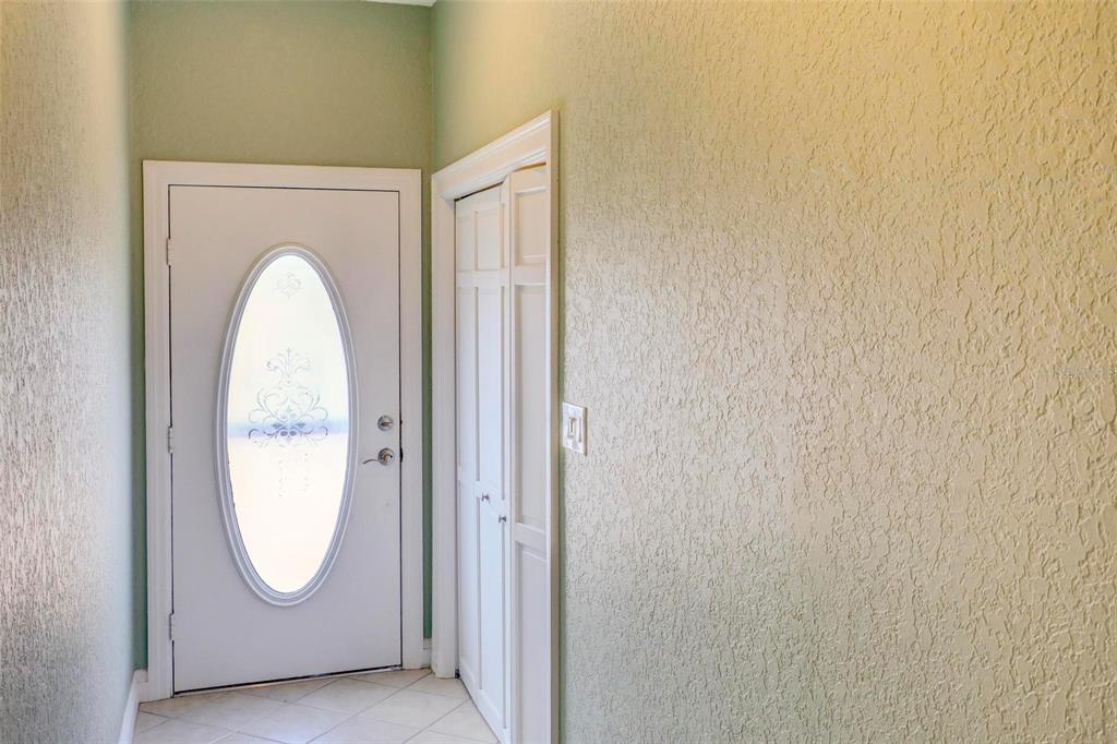 An entryway features a white front door with an oval glass insert and a closet — 7032 RIVER RUN BOULEVARD, WEEKI WACHEE, FL