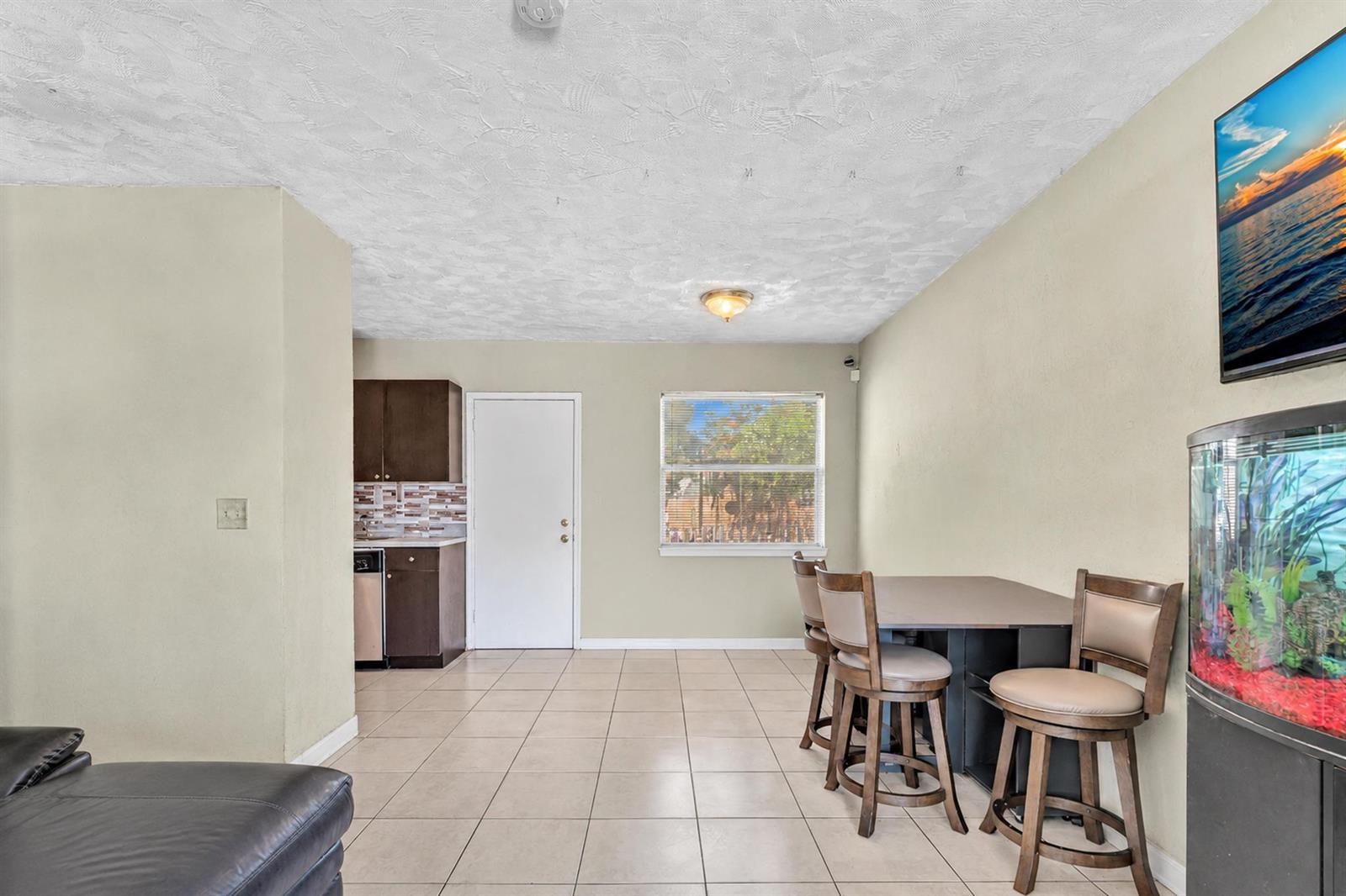 A room with tile flooring, a small kitchenette, a dining table, and a fish tank — 2743 NW 2nd Street, Boynton Beach FL 33435, BOYNTON BEACH, FL