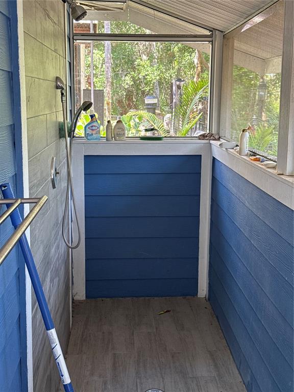 An outdoor shower features blue horizontal siding, a handheld showerhead, and a tiled floor — 6837 AMANDA VISTA CIRCLE, LAND O LAKES, FL