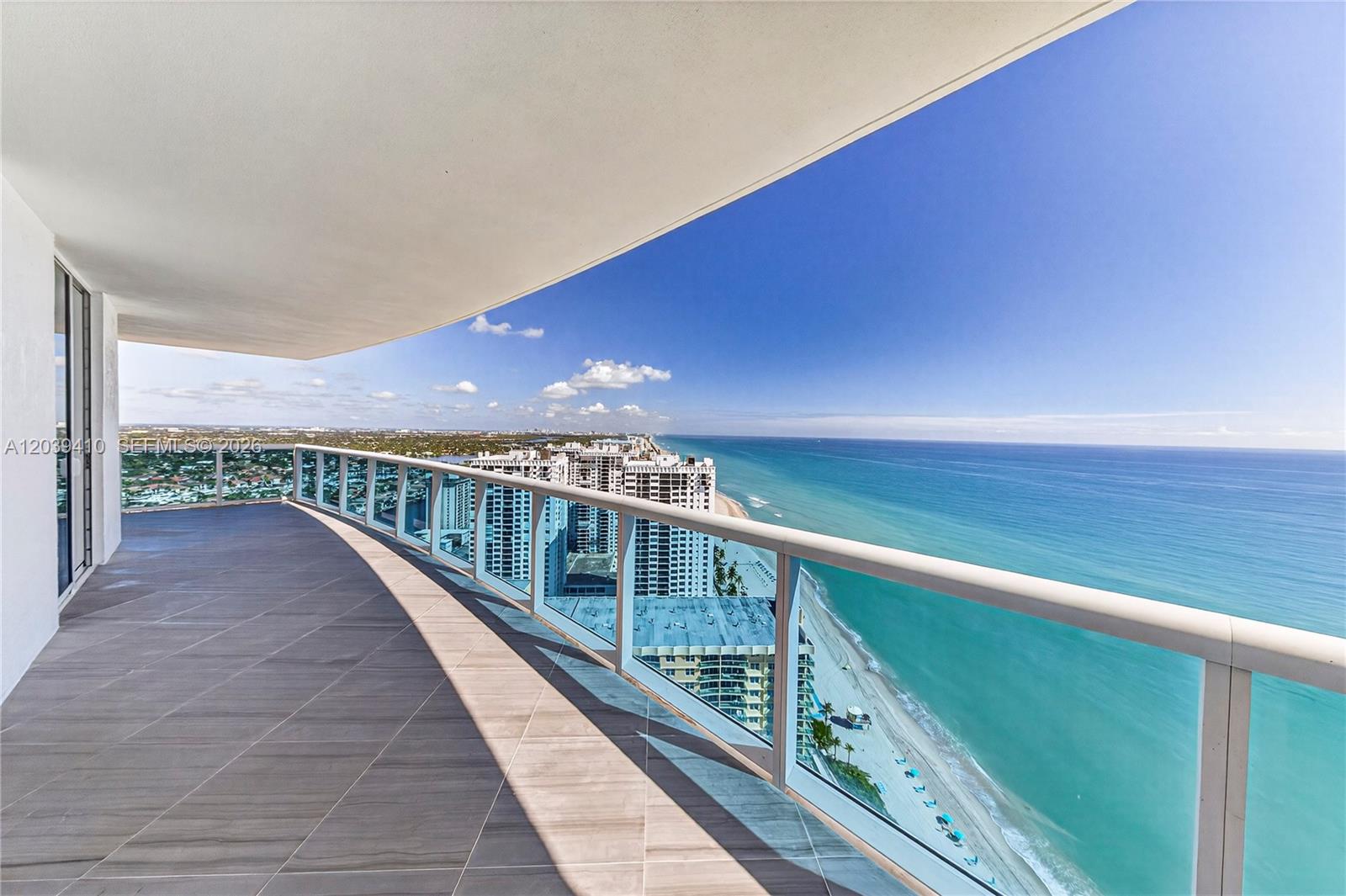 A spacious balcony with tile flooring overlooks the ocean and nearby high-rise buildings — 2711 S OCEAN DR # 3102, Hollywood FL 33024, HOLLYWOOD, FL