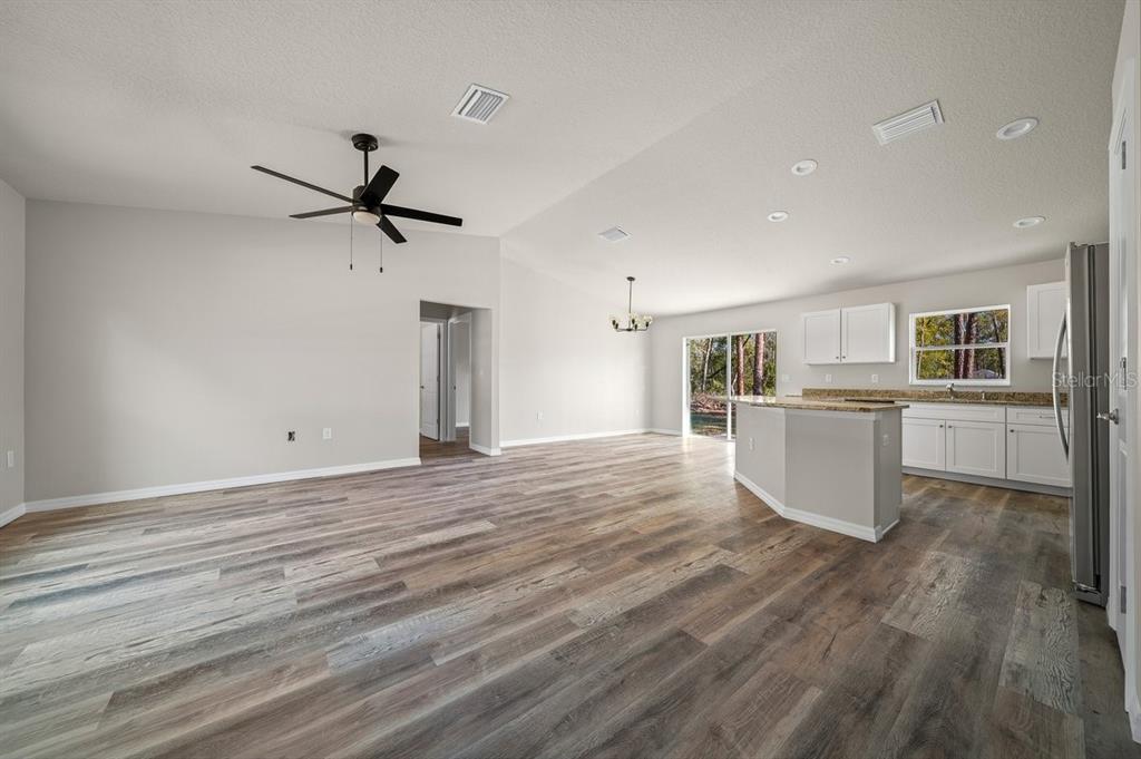 A single-story house with a white exterior, black window trim, and a concrete driveway — 1821 W WATER LILY DRIVE, CITRUS SPRINGS, FL