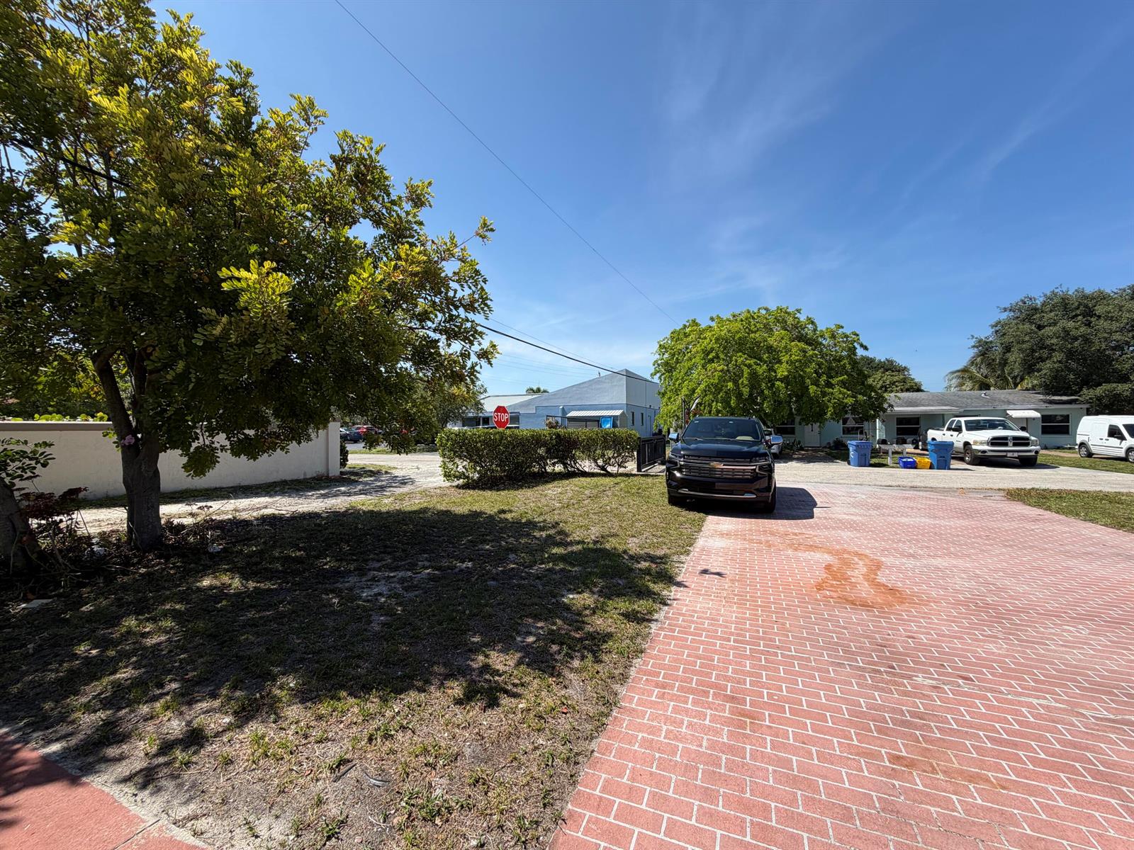 A black SUV is parked on a brick driveway in front of a residential house — 112 Prospect Road, Lantana FL 33462, LANTANA, FL