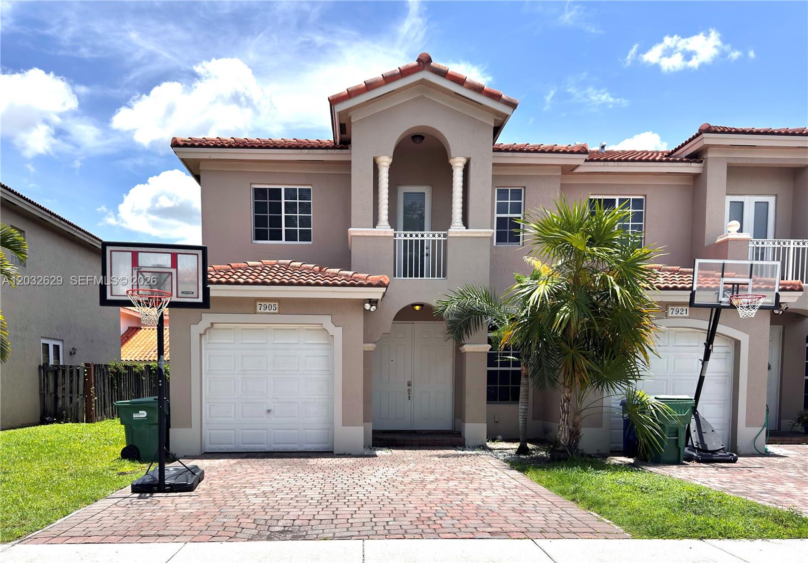 A two-story stucco townhouse with a tile roof, two garages, and two basketball hoops — 7905 SW 120th Ave # 7905, Miami FL 33183, MIAMI, FL