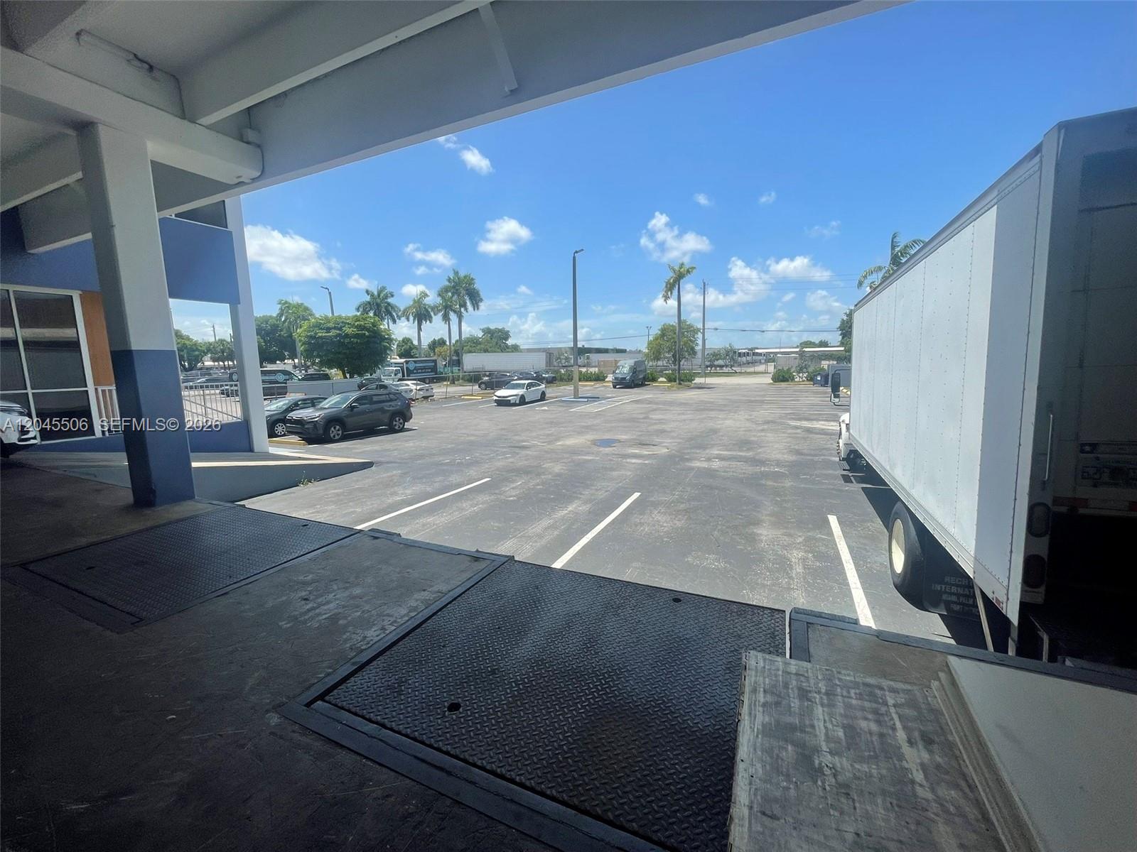 A view from a loading dock looking out over an asphalt parking lot under a sky — FL