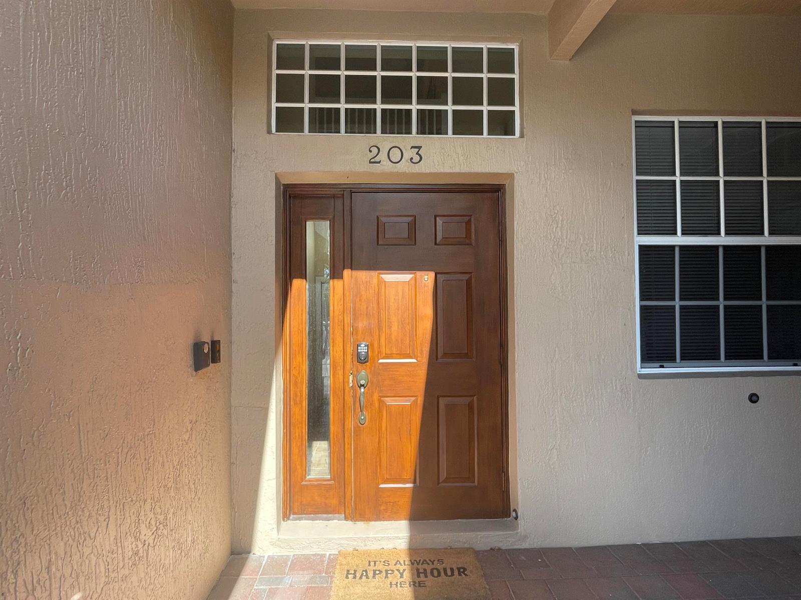A brown front door with a side window and transom window at a building entrance — 16075 Sims Road # 203, Delray Beach FL 33484, DELRAY BEACH, FL