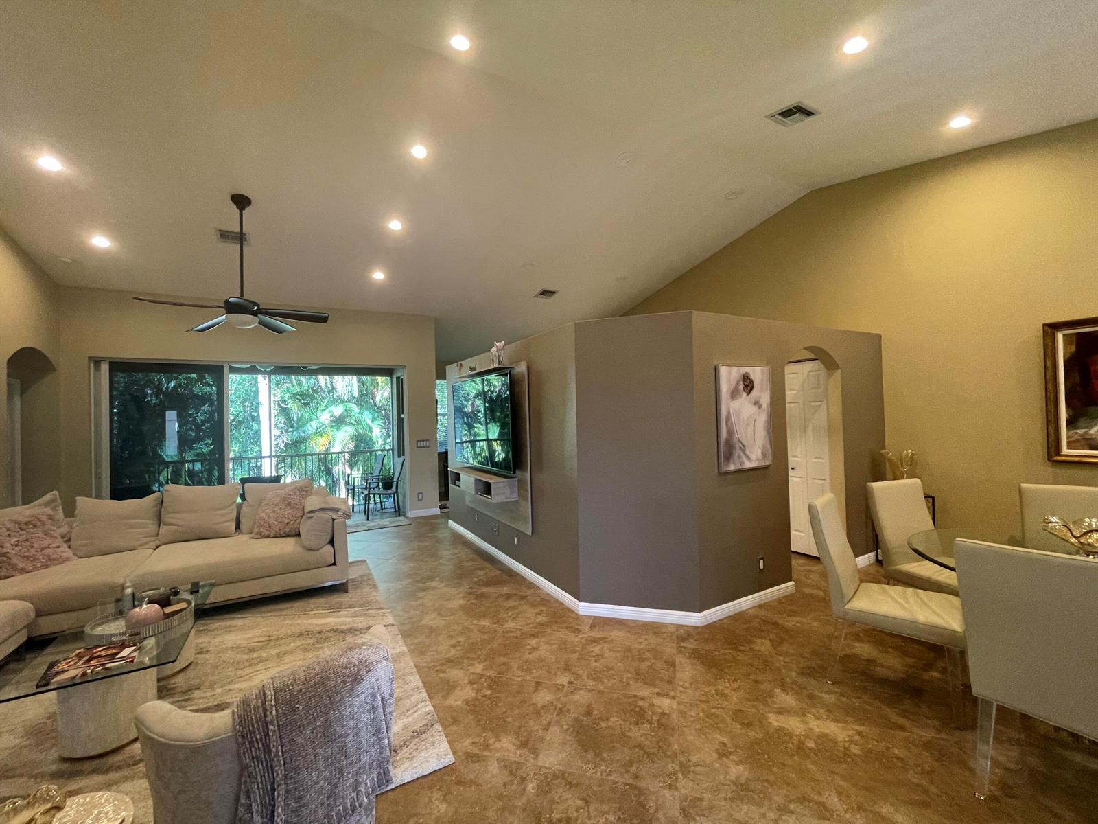 A living and dining area features vaulted ceilings, tile flooring, and a central partition wall — 16075 Sims Road # 203, Delray Beach FL 33484, DELRAY BEACH, FL
