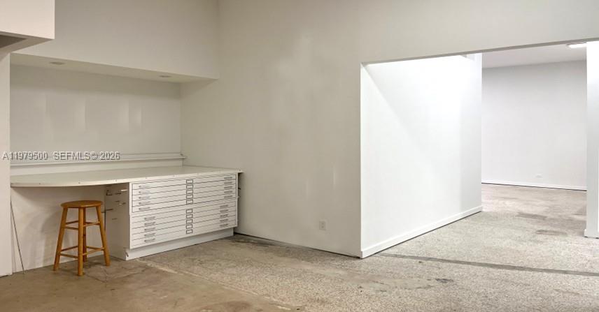 A white room features a built-in desk with a flat-file cabinet and a wooden stool — 5900 NW 2nd Ave Suite 1, Miami FL 33127, MIAMI, FL