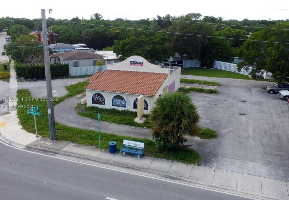 An aerial view shows a small, vacant commercial building with a tiled roof and graffiti — 14100 W Dixie Hwy, North Miami FL 33161, NORTH MIAMI, FL