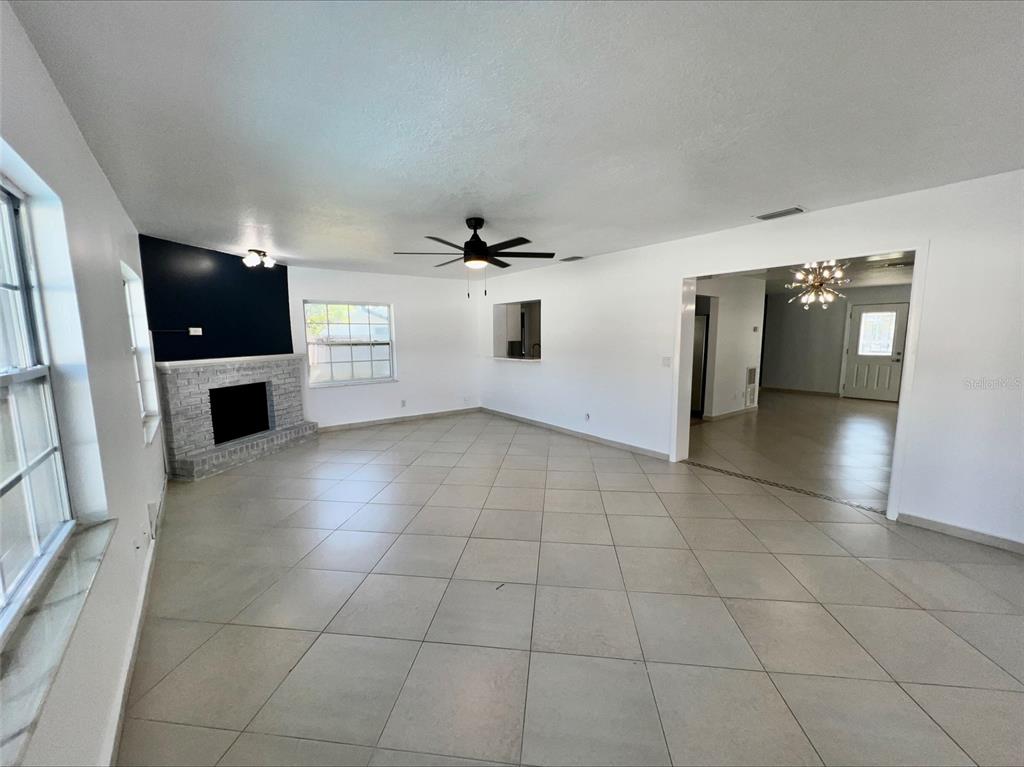 A living area features two blue velvet chairs, matching ottomans, and a floor lamp — 1211 LEHIGH STREET, KISSIMMEE, FL
