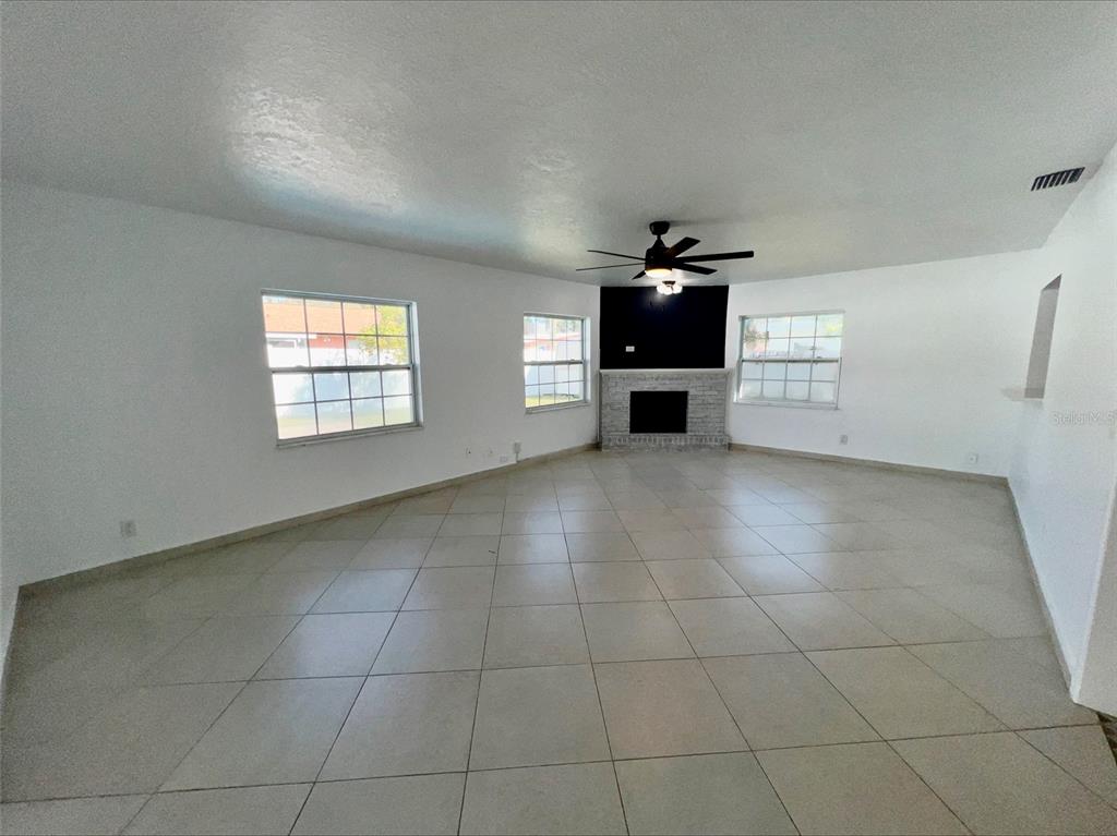 A room features a dark blue accent wall with molding, a gold-framed mirror, and tile flooring — 1211 LEHIGH STREET, KISSIMMEE, FL