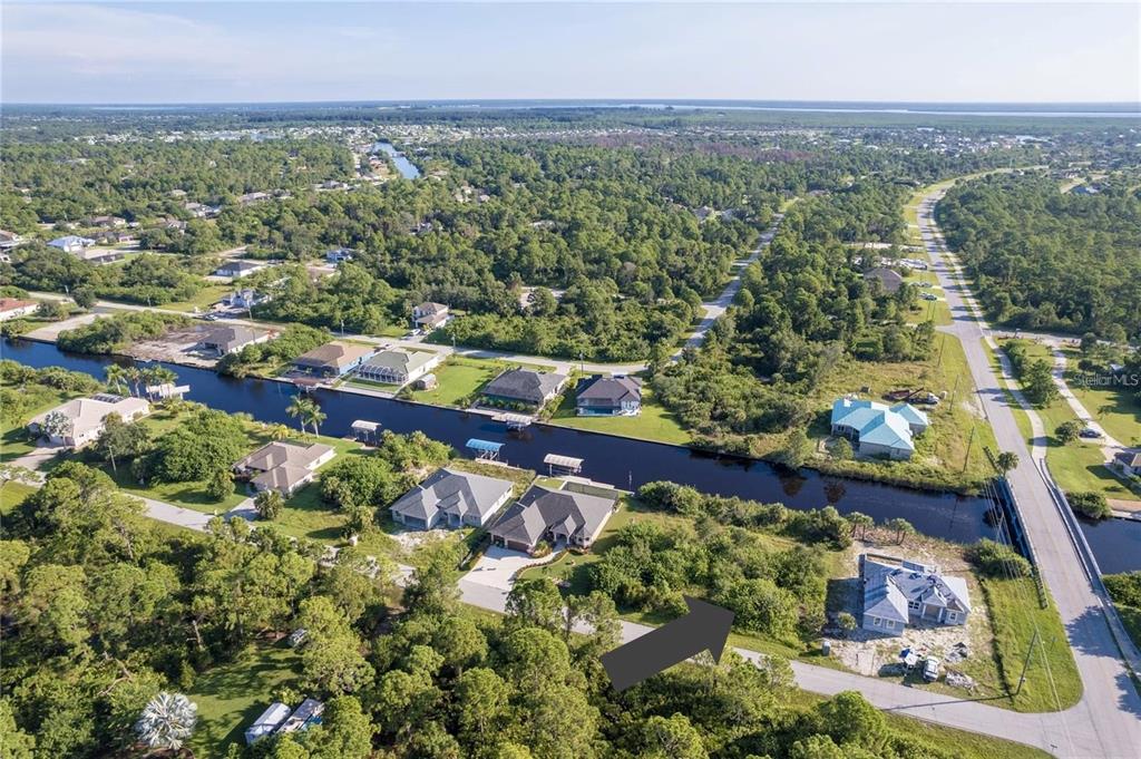 An aerial view shows a vacant lot next to a canal in a residential neighborhood — 14292 KAY LANE, PORT CHARLOTTE, FL