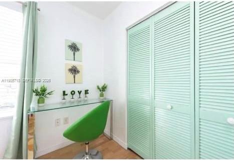 A small room features a glass desk, a green chair, and light green louvered closet doors — 7326 Collins Ave # 208, Miami Beach FL 33141, MIAMI BEACH, FL