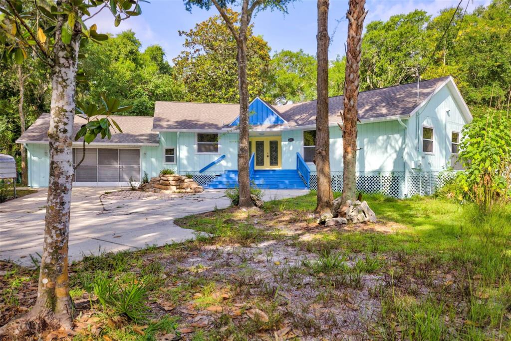 A light blue single-story house with a blue front porch and a concrete driveway — 4586 S FLAMBEAU LOOP, HOMOSASSA, FL