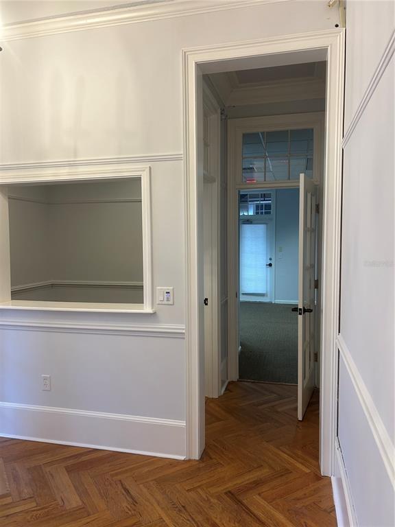 A room with herringbone wood floors, a pass-through window, and a doorway leading outside — 5214 SW 91ST TERRACE, GAINESVILLE, FL