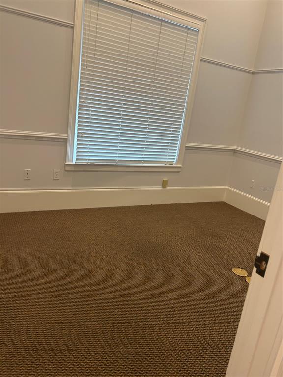 A room with light blue walls, white trim, a window with blinds, and brown carpeting — 5214 SW 91ST TERRACE, GAINESVILLE, FL