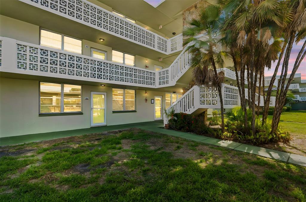 An exterior view of a multi-story apartment building with a staircase and decorative concrete screens — 4705 1ST STREET NE UNIT 138, ST PETERSBURG, FL