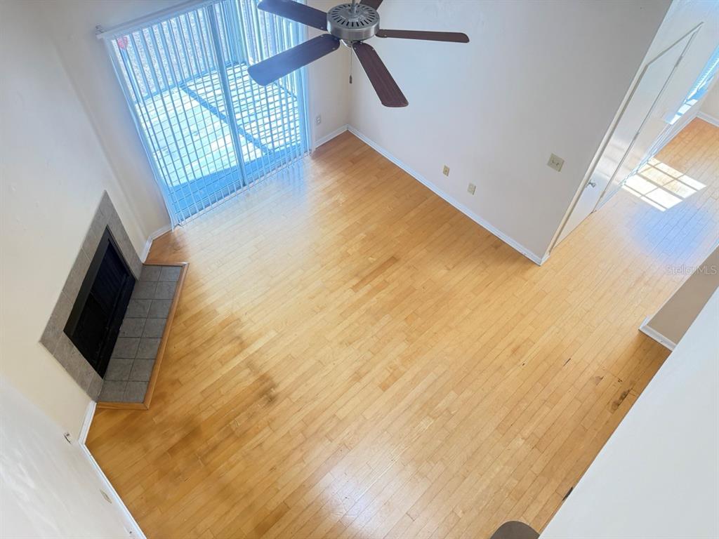 An elevated view of a living room with hardwood floors, a fireplace, and sliding doors — 6088 WESTGATE DRIVE UNIT 203, ORLANDO, FL