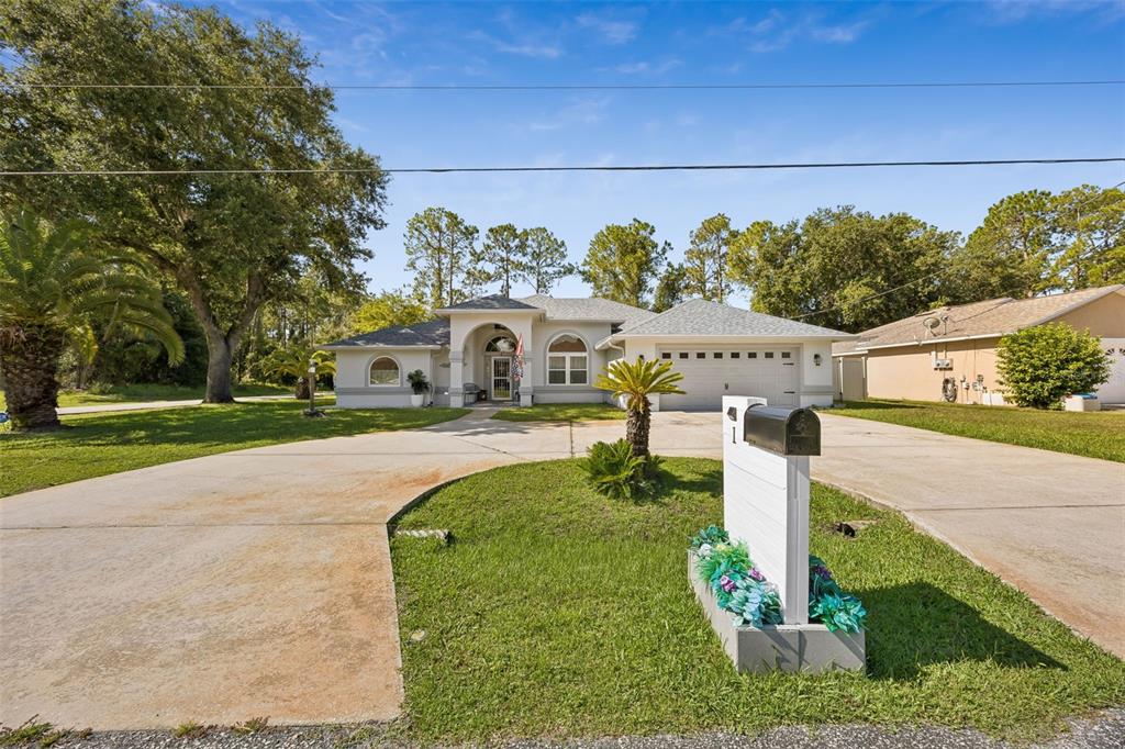 A backyard features a concrete patio, a turquoise chair, and a small storage shed — 1 BRUNSWICK LANE, PALM COAST, FL