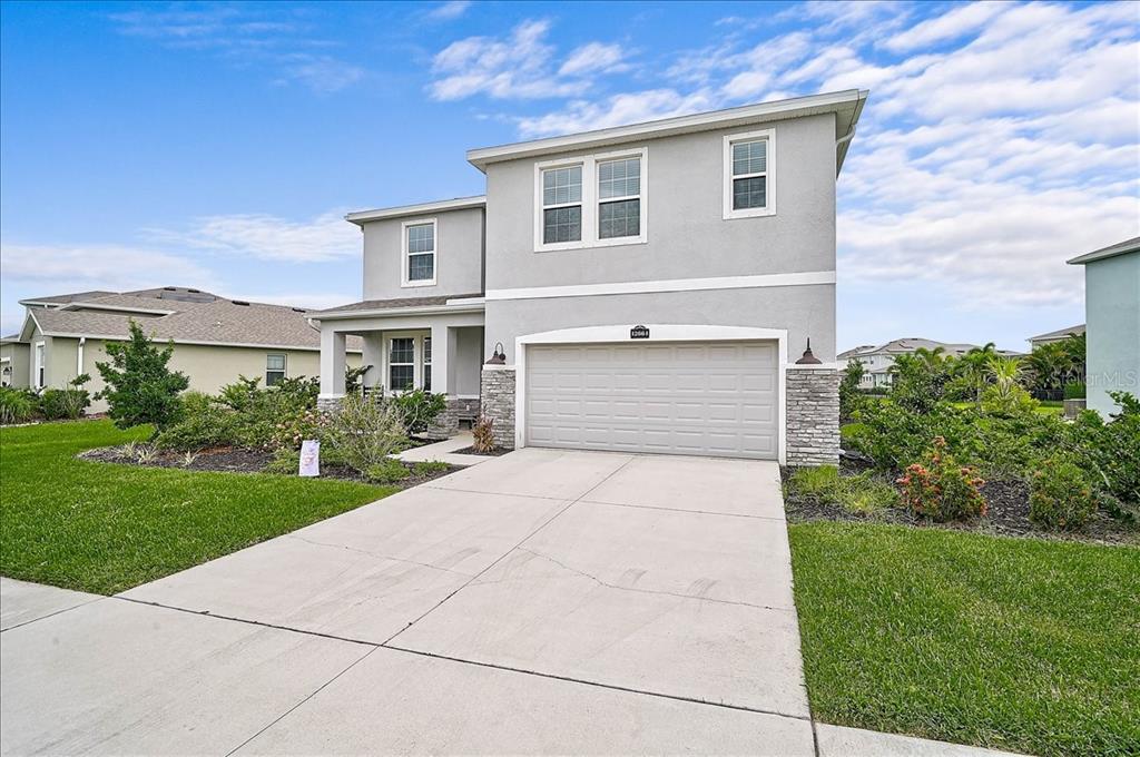 A two-story suburban house with a gray stucco exterior and a two-car garage — 12664 NIGHT VIEW DRIVE, SARASOTA, FL