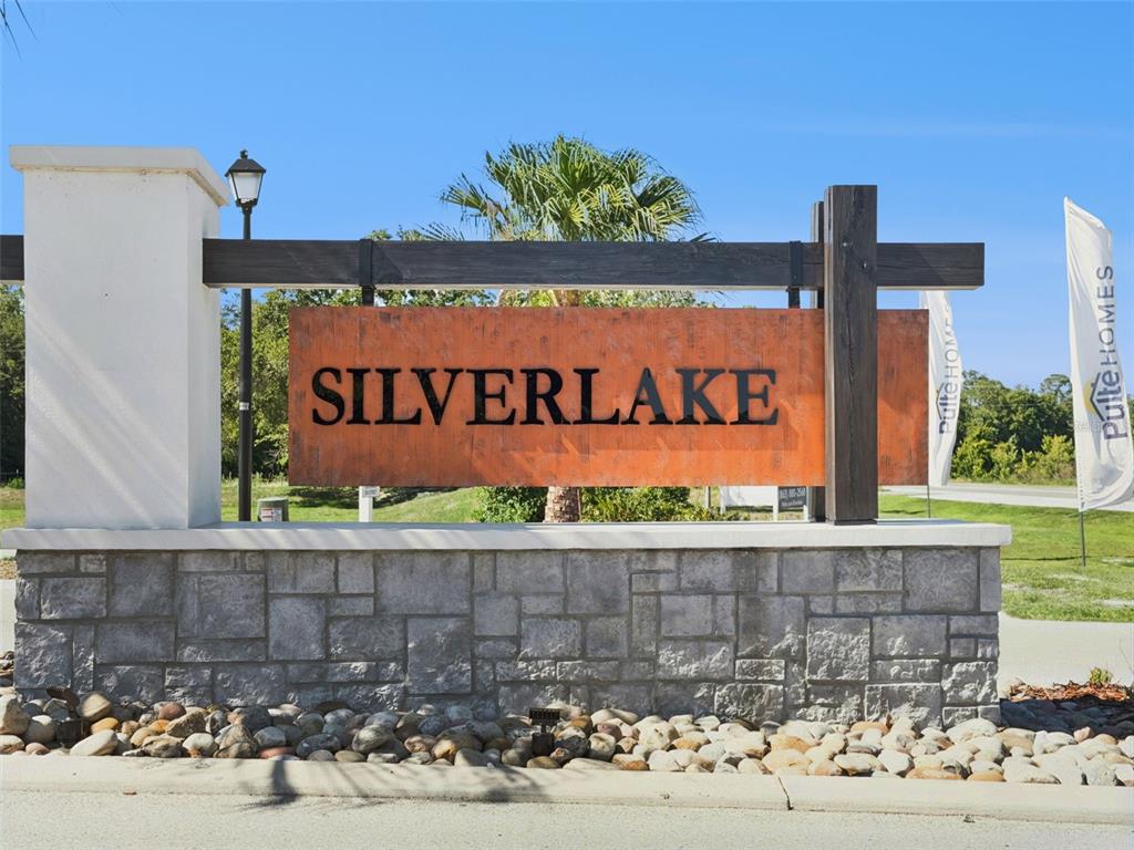 A stone-based monument sign with a rusted metal panel displays the name Silverlake — 1218 LAKERIDGE WAY, LAKE ALFRED, FL