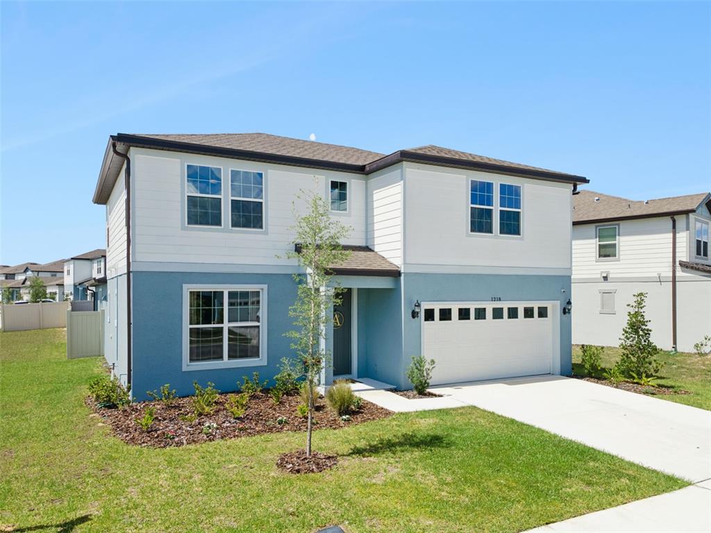A two-story house with blue stucco, white siding, and a two-car garage — 1218 LAKERIDGE WAY, LAKE ALFRED, FL