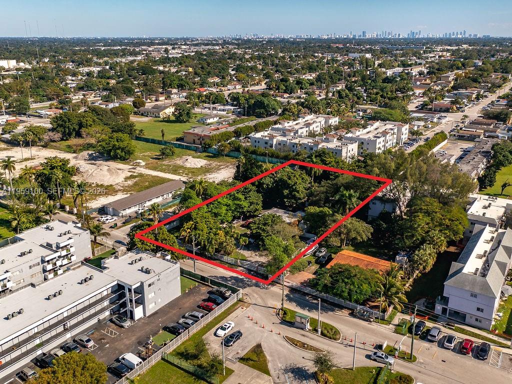 An aerial view shows a rectangular, tree-filled vacant lot outlined in red within a neighborhood — 13265 Alexandria Dr, Opa-Locka FL 33054, OPA-LOCKA, FL