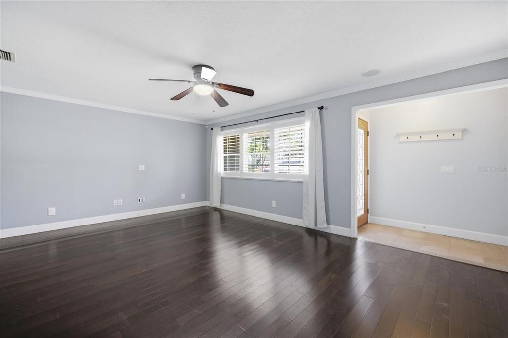 A living room with dark hardwood floors, light blue walls, and a ceiling fan — 1894 LOMA LINDA STREET, SARASOTA, FL