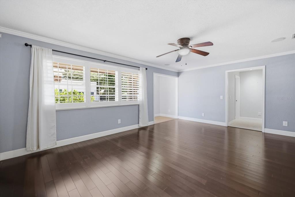 A room with light blue walls, dark hardwood floors, a ceiling fan, and large windows — 1894 LOMA LINDA STREET, SARASOTA, FL