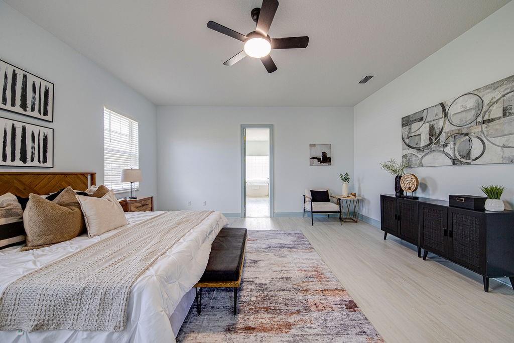 A bedroom features a bed, a black sideboard, a ceiling fan, and a rug — 4873 NE 64th Avenue, FL 34488, FL