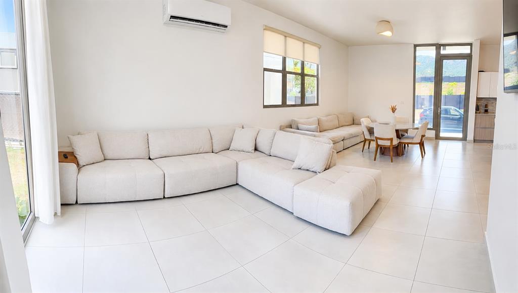 A bright living room features a large beige sectional sofa, tile flooring, and dining area — 110 St. RIVER VIEW CIUDAD JARDIN, GURABO, PR