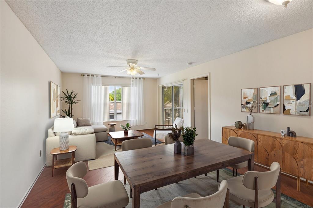 A dining area and living room with wood floors, a ceiling fan, and sliding glass doors — 7713 HILLSIDE COURT UNIT 204, HUDSON, FL