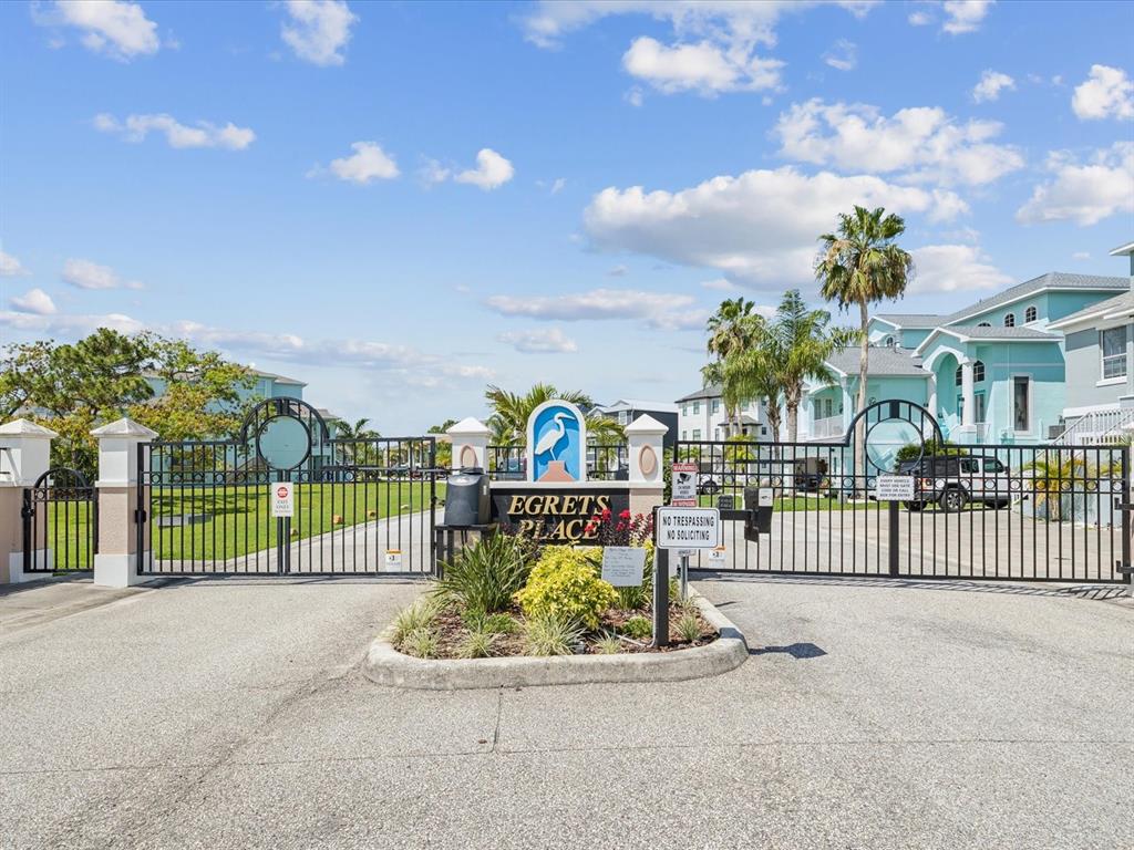 A gated entrance with a sign reading Egrets Place leads to a residential complex — 5621 EGRETS PLACE, NEW PORT RICHEY, FL