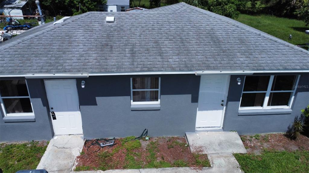 An aerial view of a gray house exterior with two white doors and two windows — 3715 AVENUE J NW, WINTER HAVEN, FL