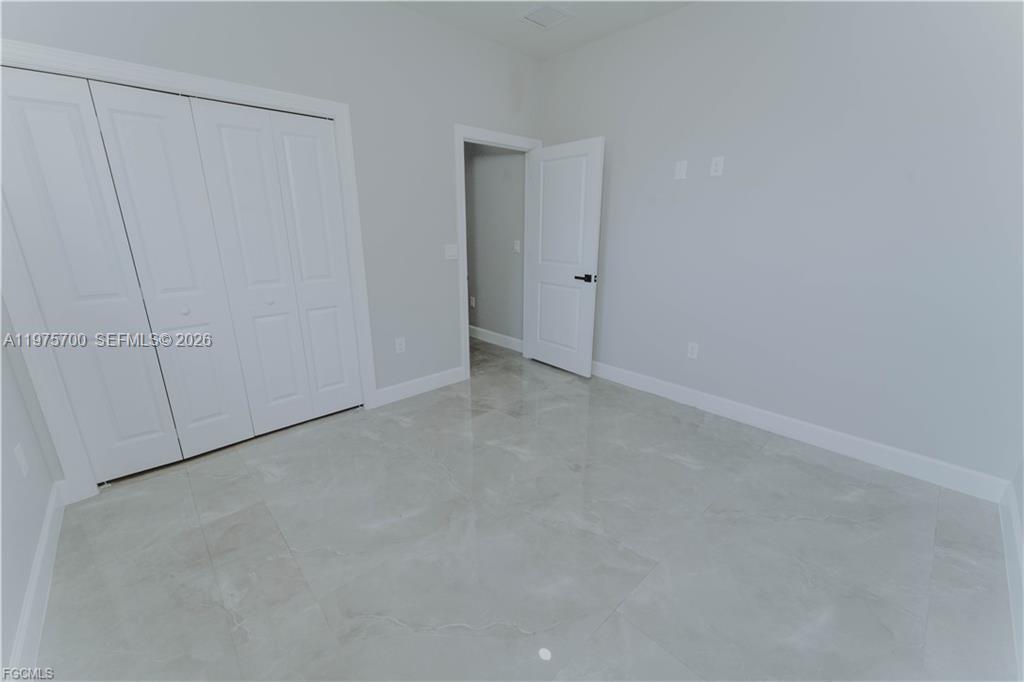 A room with light gray walls, white trim, and large, glossy, light-colored floor tiles — 4705 diane ave, Lehigh Acres FL 33976, LEHIGH ACRES, FL